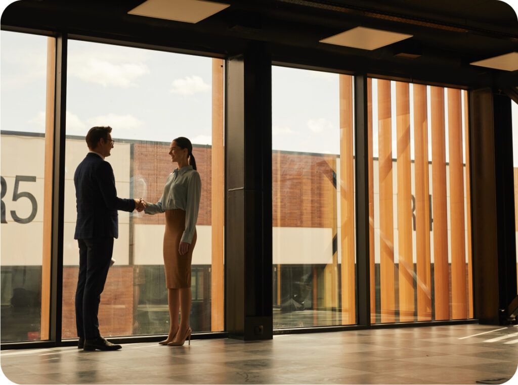 two people shaking hands in office building